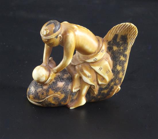 A Japanese ivory netsuke of a man riding a cat fish, 19th century, signed Shunkosai, 5cm